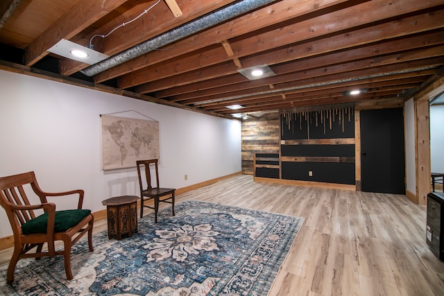 living area with beam ceiling and light hardwood / wood-style flooring