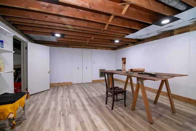 basement featuring heating unit and light hardwood / wood-style flooring