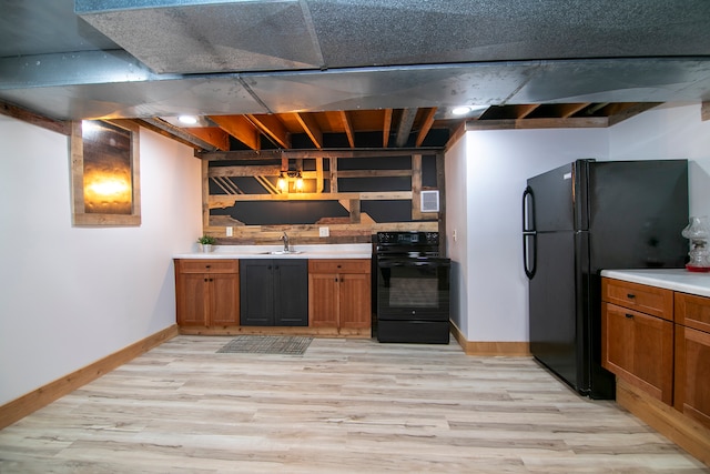 kitchen featuring sink, hanging light fixtures, black appliances, and light wood-type flooring