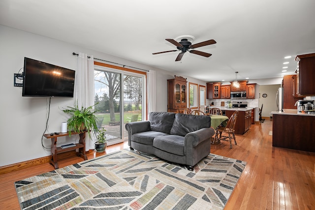 living room with ceiling fan and light wood-type flooring