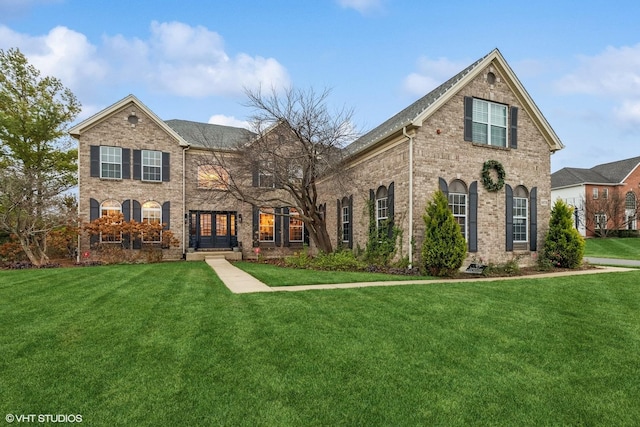 view of front of house with brick siding and a front yard