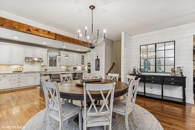 dining room with recessed lighting, hardwood / wood-style flooring, and a notable chandelier