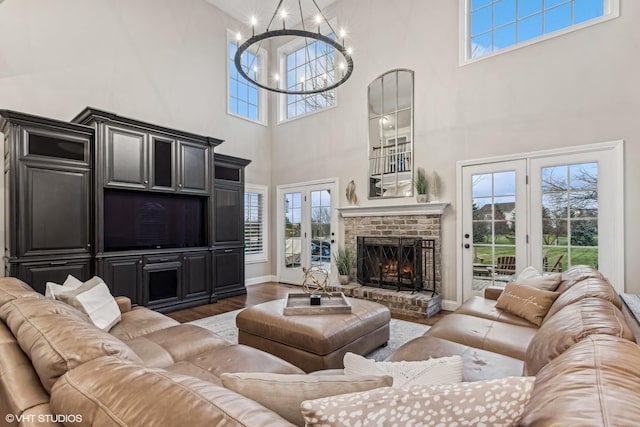 living room with french doors, a healthy amount of sunlight, a fireplace, and wood finished floors