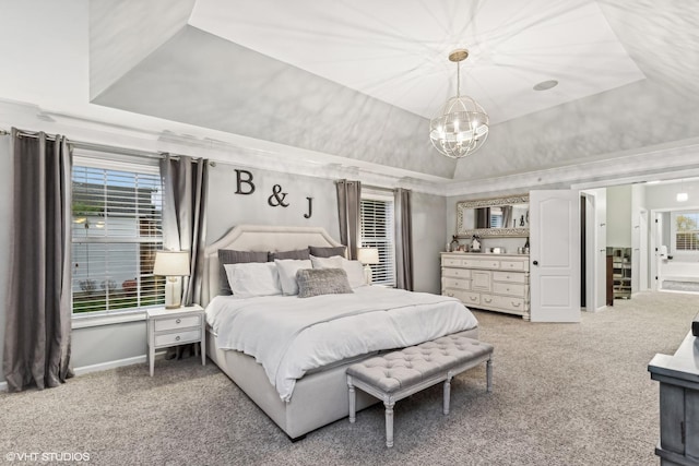 bedroom featuring carpet floors, a tray ceiling, multiple windows, and a notable chandelier