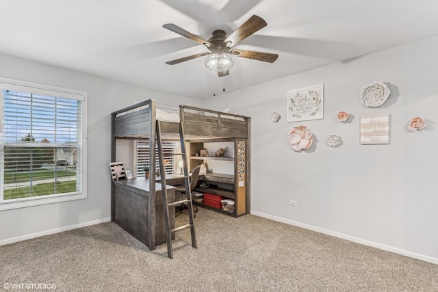 interior space featuring carpet, baseboards, and a ceiling fan