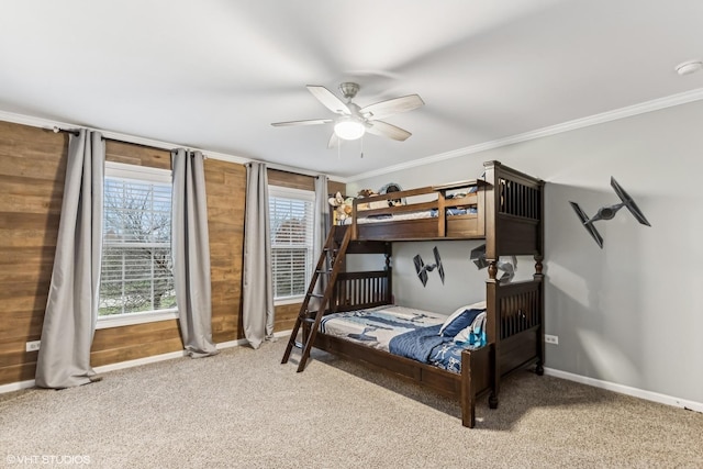 carpeted bedroom featuring a ceiling fan, crown molding, and baseboards