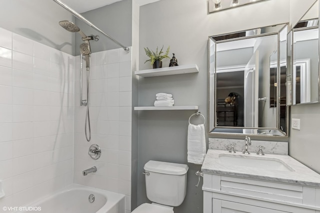 bathroom with washtub / shower combination, vanity, and toilet