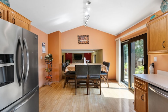 kitchen with rail lighting, stainless steel appliances, light hardwood / wood-style flooring, and vaulted ceiling