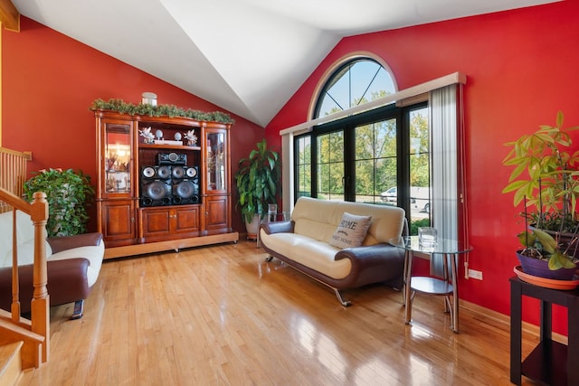 living area featuring french doors, light hardwood / wood-style floors, and vaulted ceiling