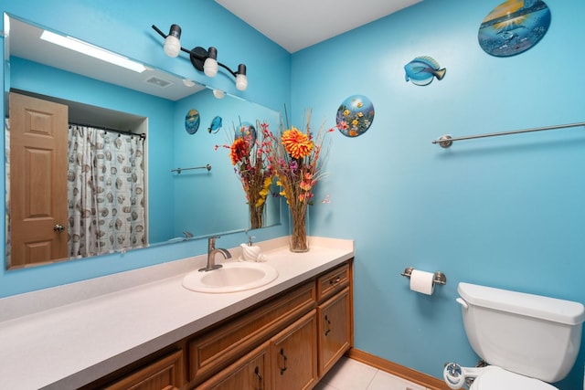 bathroom featuring tile patterned flooring, vanity, and toilet