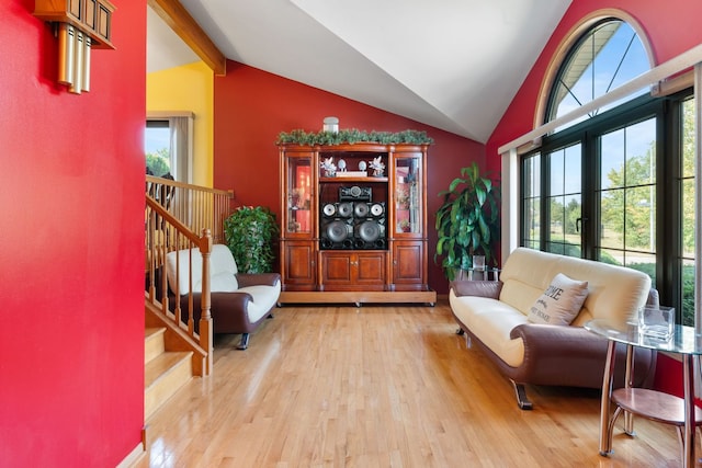 living area featuring lofted ceiling with beams, french doors, and light hardwood / wood-style floors