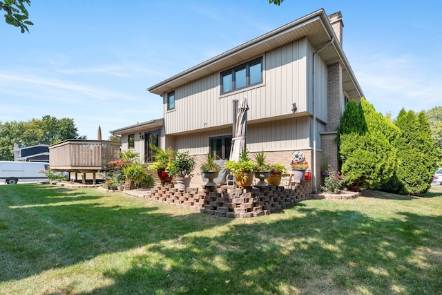 back of house with a lawn and a deck