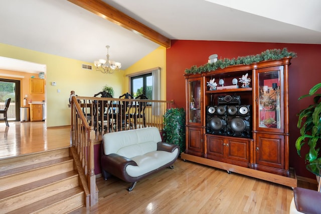 living area with vaulted ceiling with beams, a chandelier, and light hardwood / wood-style floors