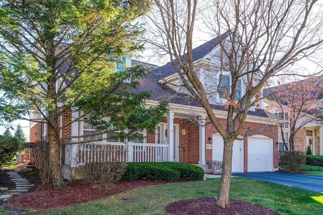 view of front of house with covered porch, a garage, and a front yard