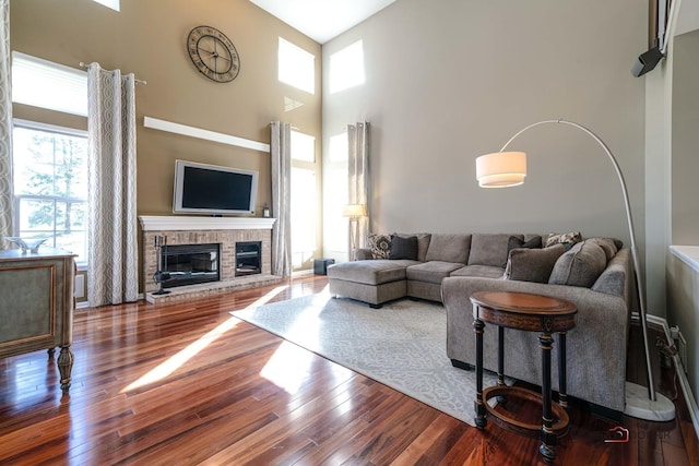 living room featuring a fireplace, a high ceiling, and hardwood / wood-style flooring