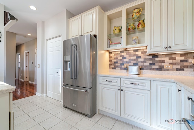 kitchen featuring decorative backsplash, high quality fridge, and light tile patterned flooring