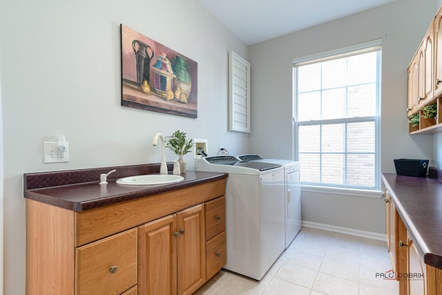 laundry room featuring cabinets, sink, plenty of natural light, and washing machine and clothes dryer