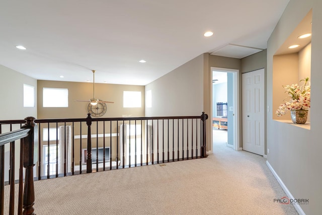 hall featuring plenty of natural light and light colored carpet