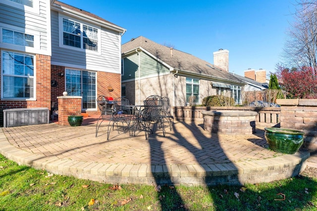 rear view of property with an outdoor fire pit and a patio area