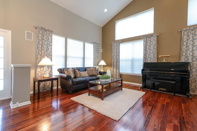 living room with dark wood-type flooring and high vaulted ceiling