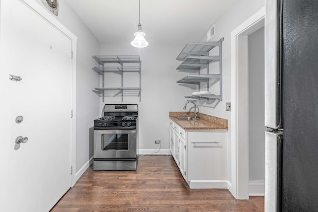 kitchen featuring sink, hanging light fixtures, appliances with stainless steel finishes, dark hardwood / wood-style flooring, and white cabinetry