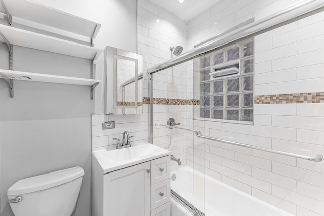 full bathroom featuring vanity, toilet, shower / bath combination with glass door, and tasteful backsplash