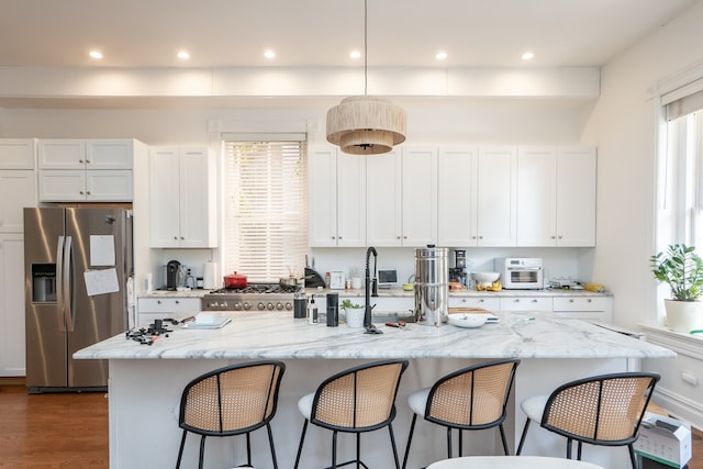 kitchen featuring a center island with sink, white cabinetry, dark wood-type flooring, and appliances with stainless steel finishes