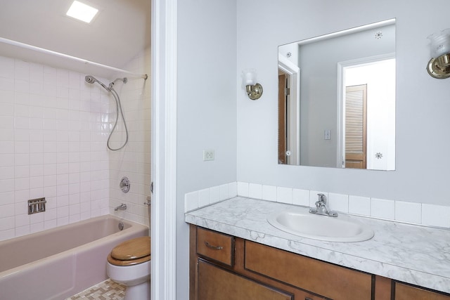 full bathroom with vanity, tiled shower / bath combo, and toilet