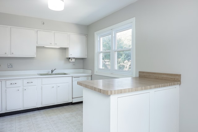 kitchen with white dishwasher, sink, light tile patterned floors, white cabinetry, and kitchen peninsula