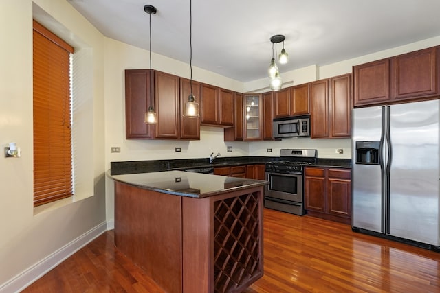 kitchen with sink, dark wood-type flooring, pendant lighting, and appliances with stainless steel finishes