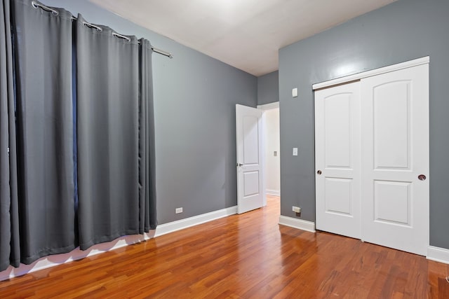 unfurnished bedroom featuring hardwood / wood-style floors and a closet