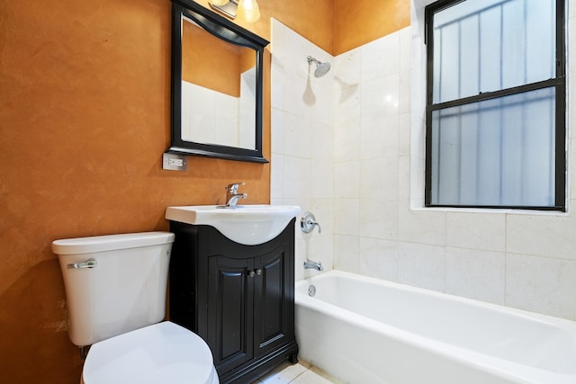 full bathroom featuring tiled shower / bath, vanity, and toilet