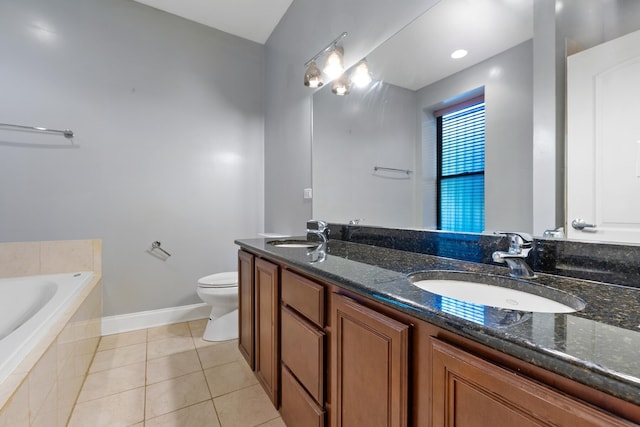 bathroom with tile patterned floors, vanity, toilet, and tiled bath