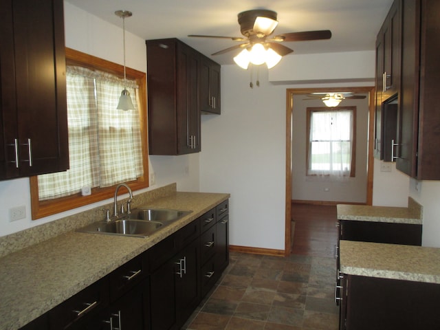 kitchen featuring dark brown cabinets, decorative light fixtures, ceiling fan, and sink