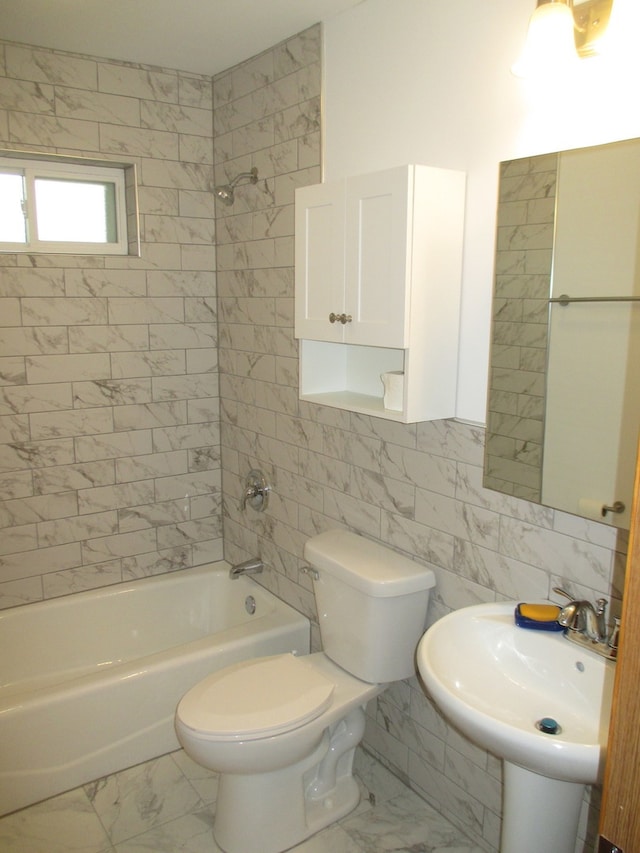 full bathroom with tiled shower / bath combo, toilet, tile walls, and sink