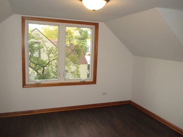 additional living space with dark hardwood / wood-style floors and vaulted ceiling