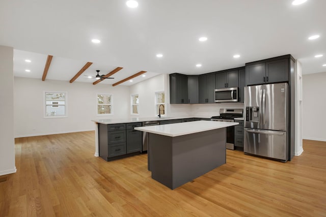 kitchen with a center island, stainless steel appliances, ceiling fan, light hardwood / wood-style flooring, and vaulted ceiling with beams