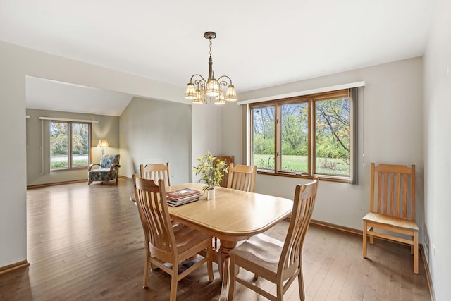 dining space featuring hardwood / wood-style floors and a chandelier