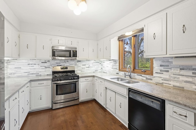 kitchen with tasteful backsplash, stainless steel appliances, sink, white cabinets, and dark hardwood / wood-style floors