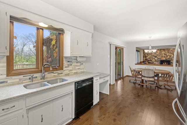 kitchen featuring white cabinets, sink, black dishwasher, decorative light fixtures, and dark hardwood / wood-style flooring