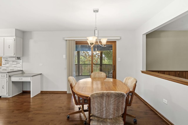 dining space with dark wood-type flooring and a notable chandelier