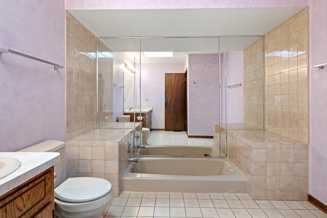 bathroom featuring tile patterned floors, vanity, toilet, and a bathing tub