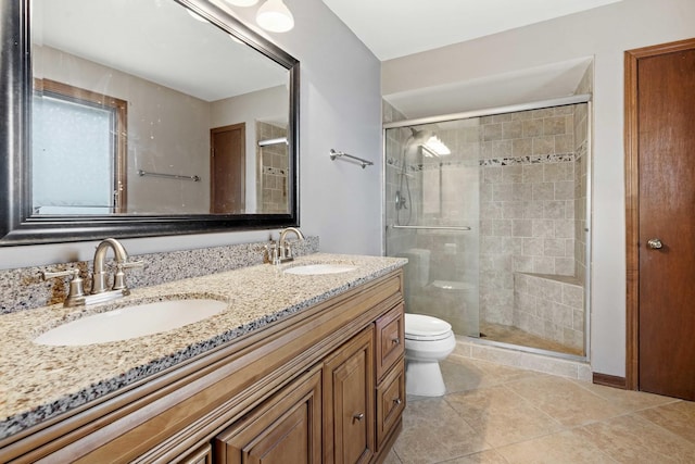 bathroom featuring tile patterned flooring, vanity, toilet, and a shower with shower door