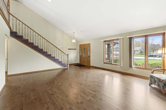 unfurnished living room with hardwood / wood-style floors and a notable chandelier