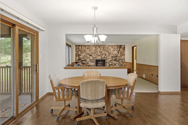 dining area featuring hardwood / wood-style flooring, a notable chandelier, and wood walls