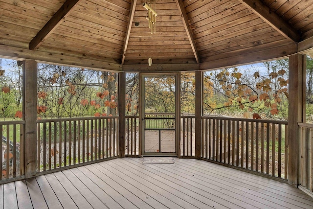 unfurnished sunroom with vaulted ceiling with beams and wooden ceiling