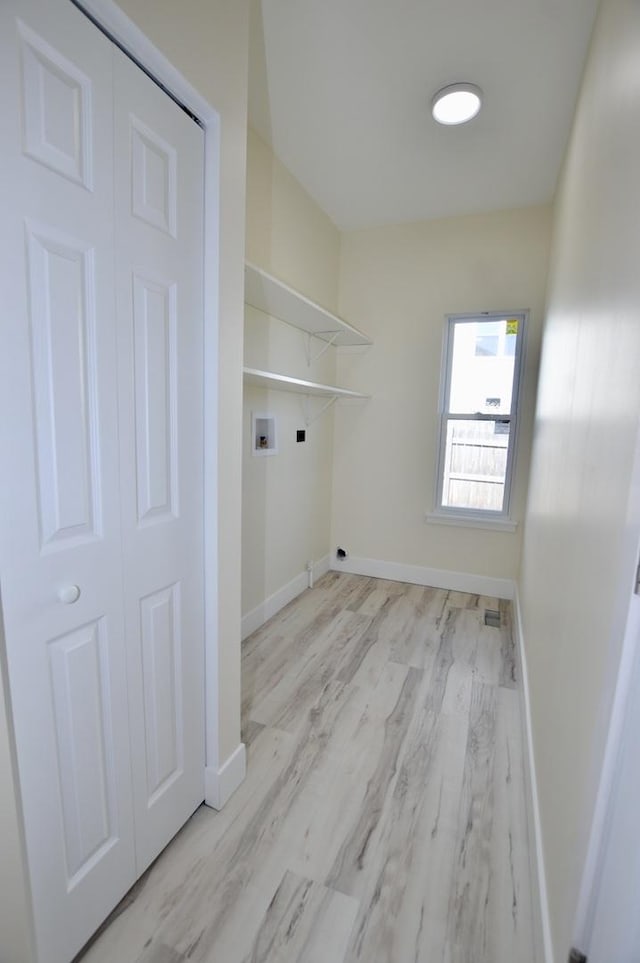 laundry area featuring washer hookup, laundry area, wood finished floors, and baseboards