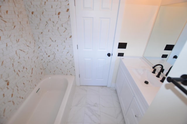 full bath featuring a bathtub, marble finish floor, and vanity