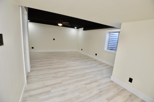 basement featuring light wood-style flooring and baseboards