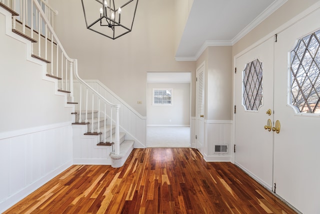 entryway featuring dark hardwood / wood-style flooring, a chandelier, french doors, and ornamental molding